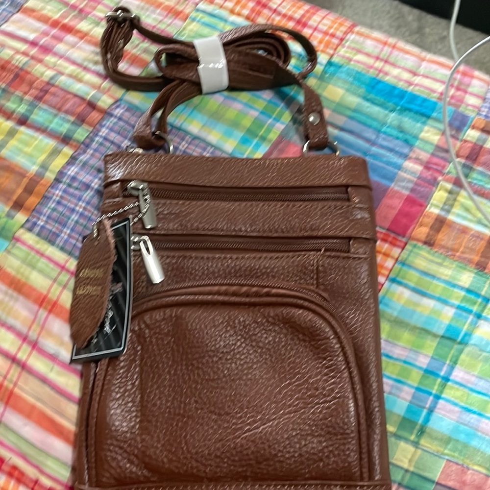 Leather crossbody with four different zippered sections and a built in wallet